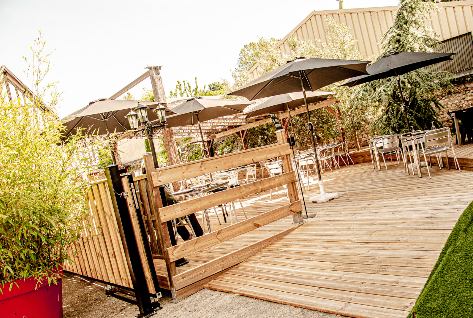Terrasse en bois ombragée par de grands parasols au restaurant Les Saveurs du Liban et de l’Orient, au Petit Andely